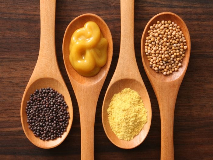 four spoons with varieties of mustard shot from above