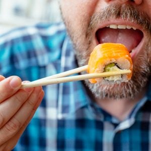 close up of man eating sushi