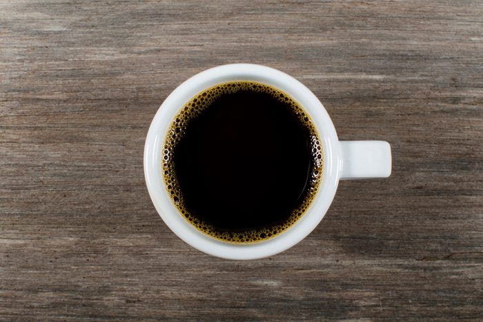Mug of coffee on wooden background