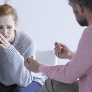 Young woman having post abortion stress, talking with psychologist