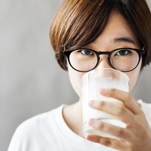 woman drinking glass of milk beverage