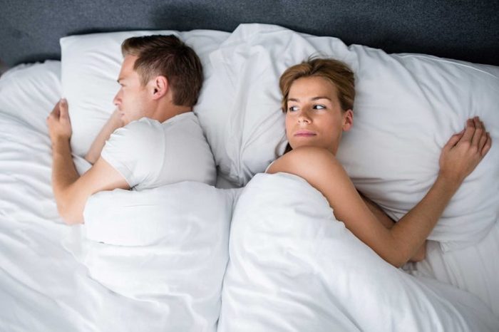 Man sound asleep with woman watching him