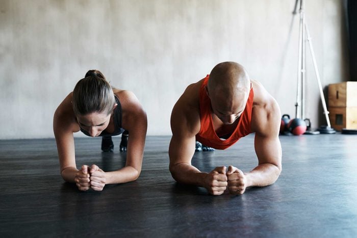 fit man and woman doing plank together