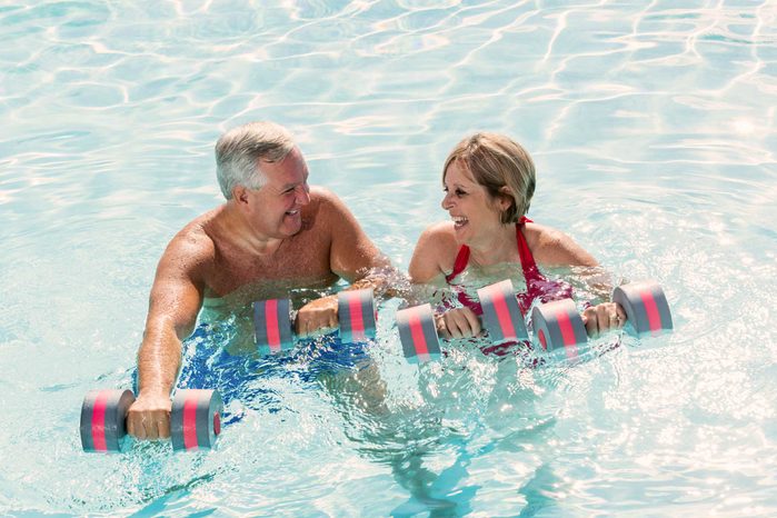 mature man and woman exercising in pool