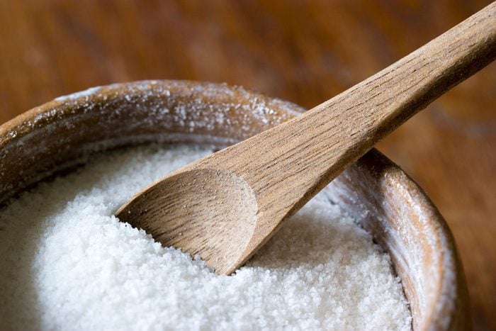 wooden bowl full of salt with wooden spoon