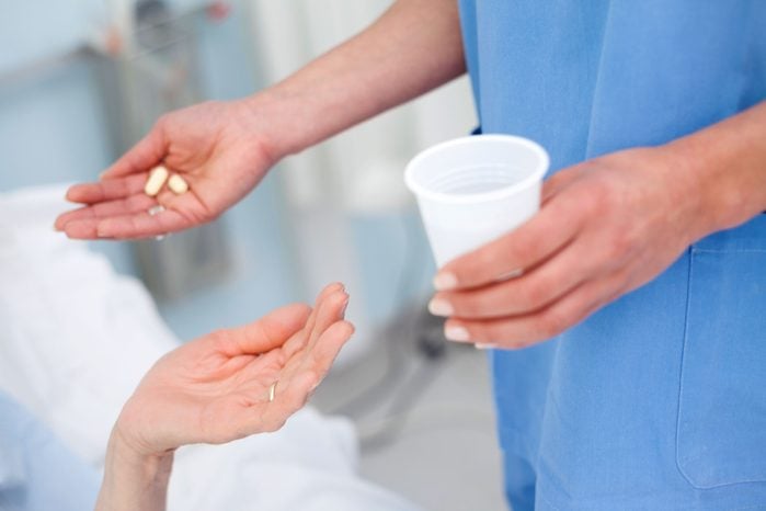 nurse handing a patient pills and water