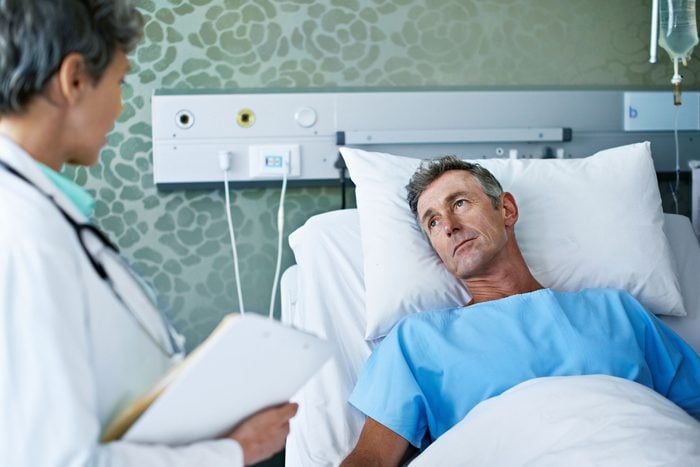 doctor talking to a patient who is in a hospital bed