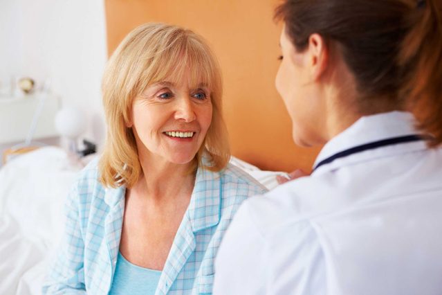Woman doctor talking to an elderly female patient