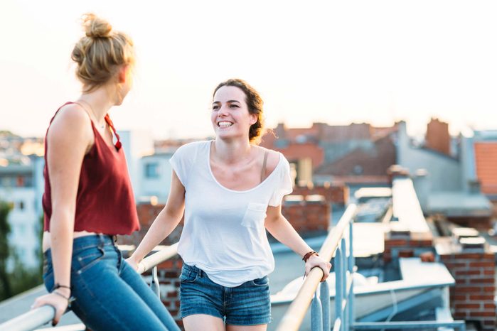 two women talking on a rooftop