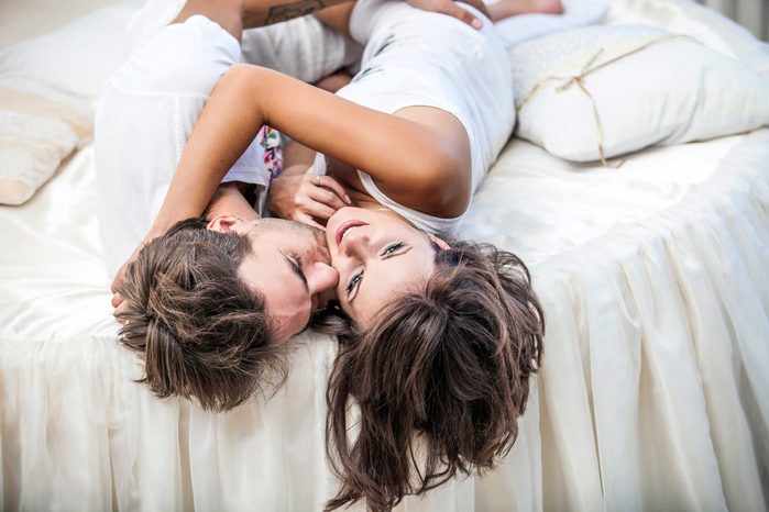 man and woman embracing in bed