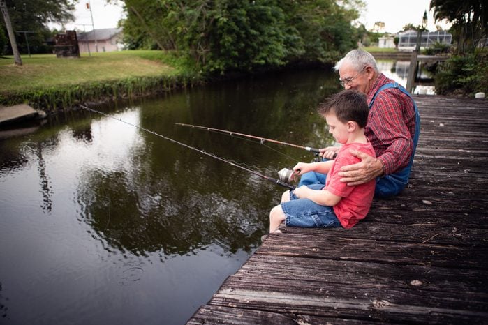 older man and boy fishing off a dock