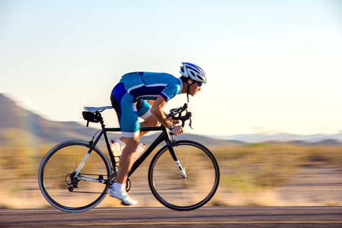 Elite athlete cyclist biking on a road.