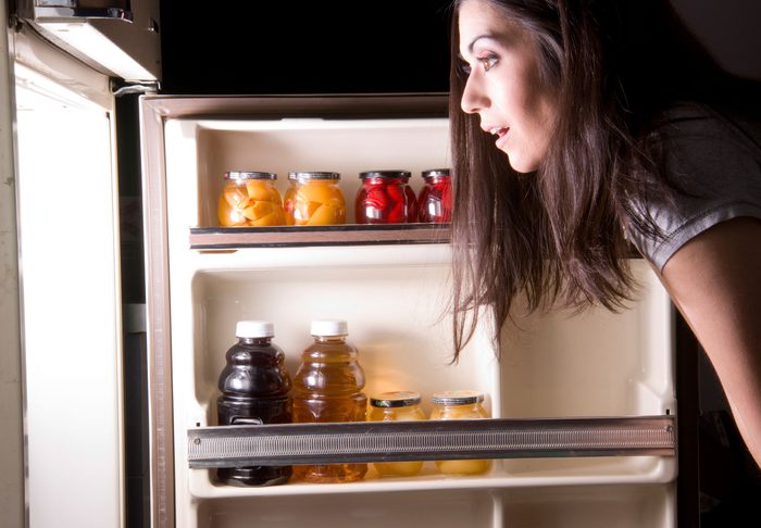 woman looking into a refrigerator