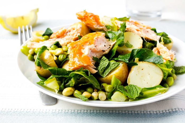 salmon on salad on white plate with fork