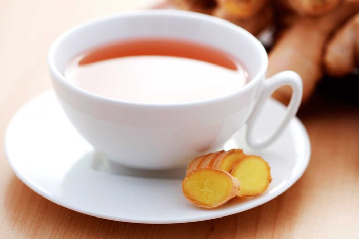 white cup of tea with ginger on side