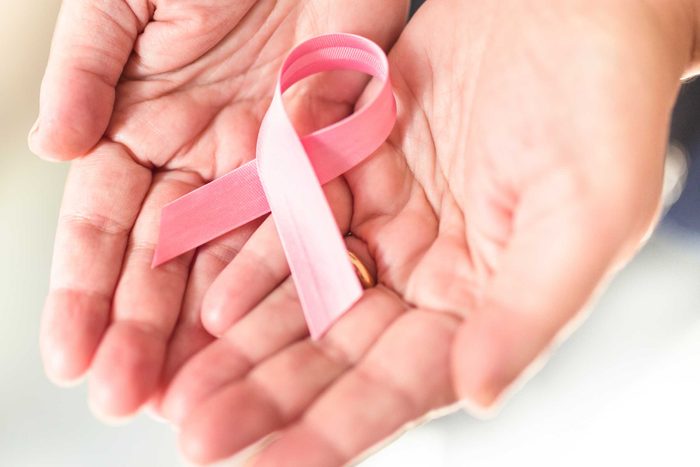 hands holding pink breast cancer ribbon
