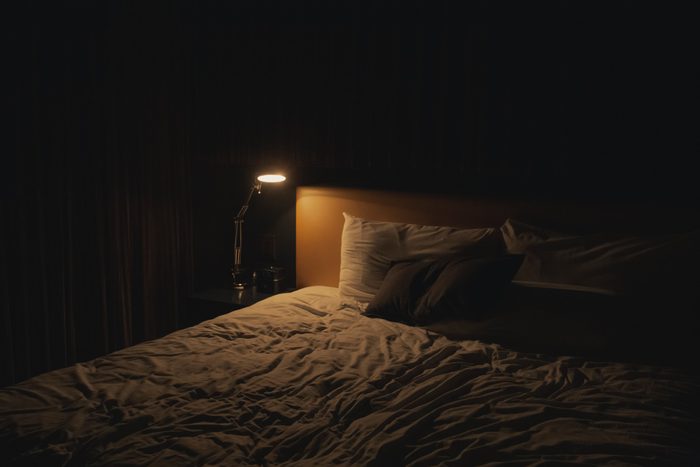 dark bedroom at night with table lamp on