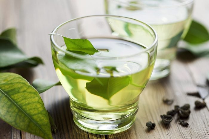 clear glass of green tea with leaves