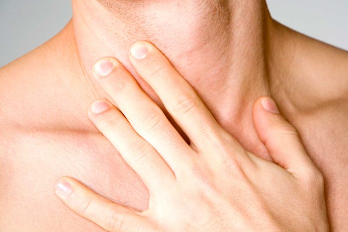 woman's hand on her clavicle