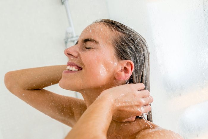 woman showering with eyes closed
