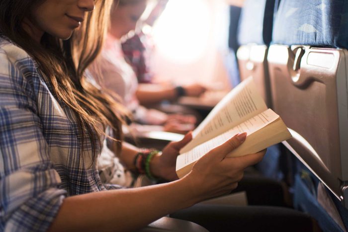 woman on a plane reading a book
