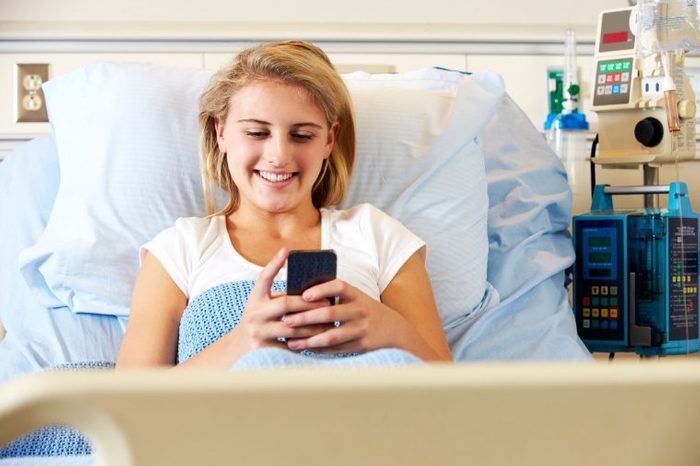 patient in hospital bed on phone