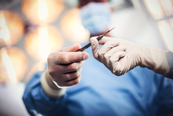 gloved surgeon handling instrument