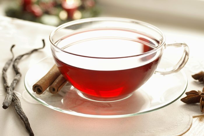 Red cup of tea with cloves and cinnamon. 