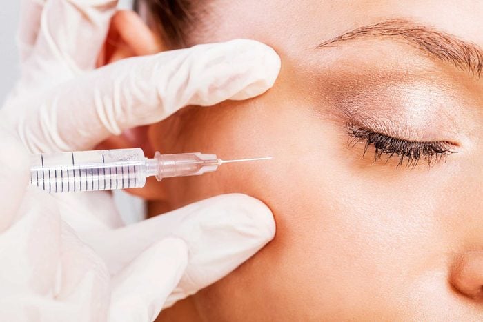 Woman receiving a Botox injection near her eye.