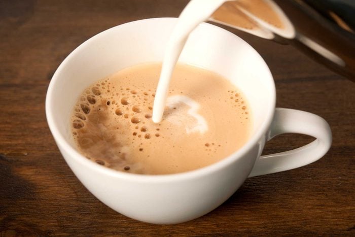 milk pouring into a mug of coffee