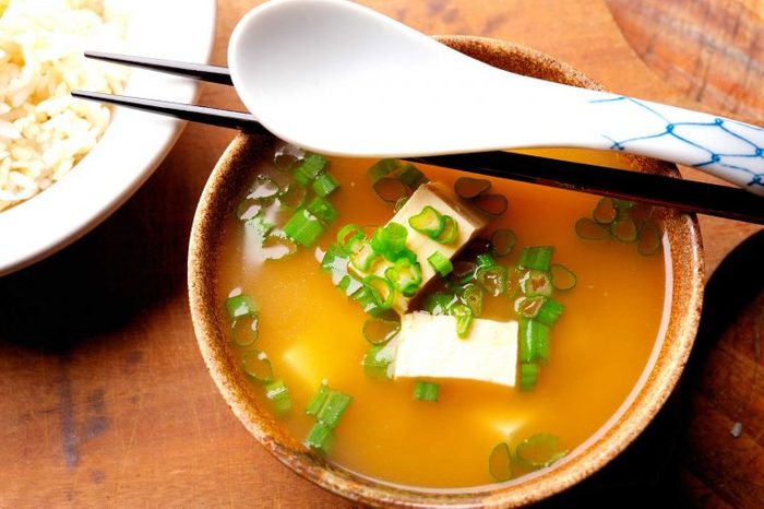 Bowl of miso soup with tofu and green onions.