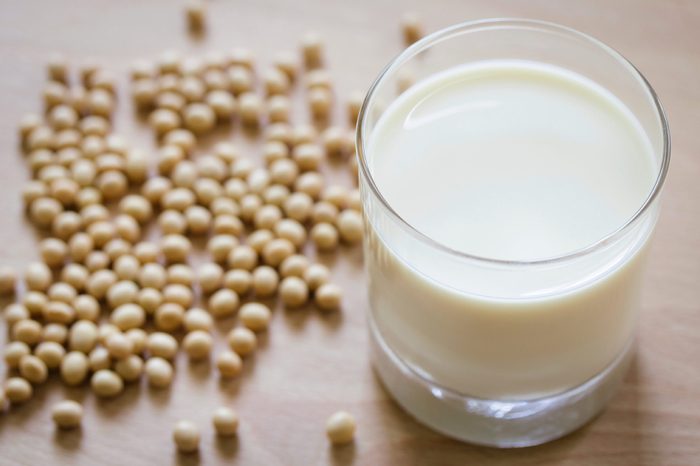Glass of milk with soybeans on the table.
