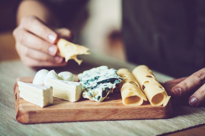 close up of cheese plate; person's hands
