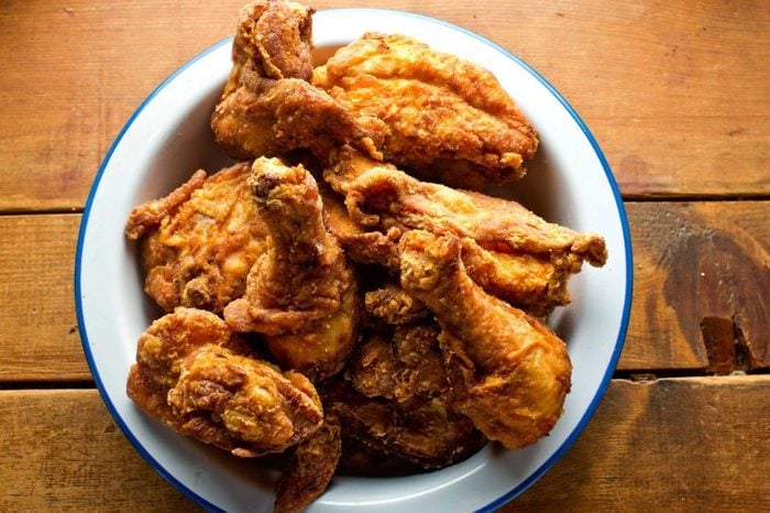 Bowl of crispy, fried chicken wings and legs.
