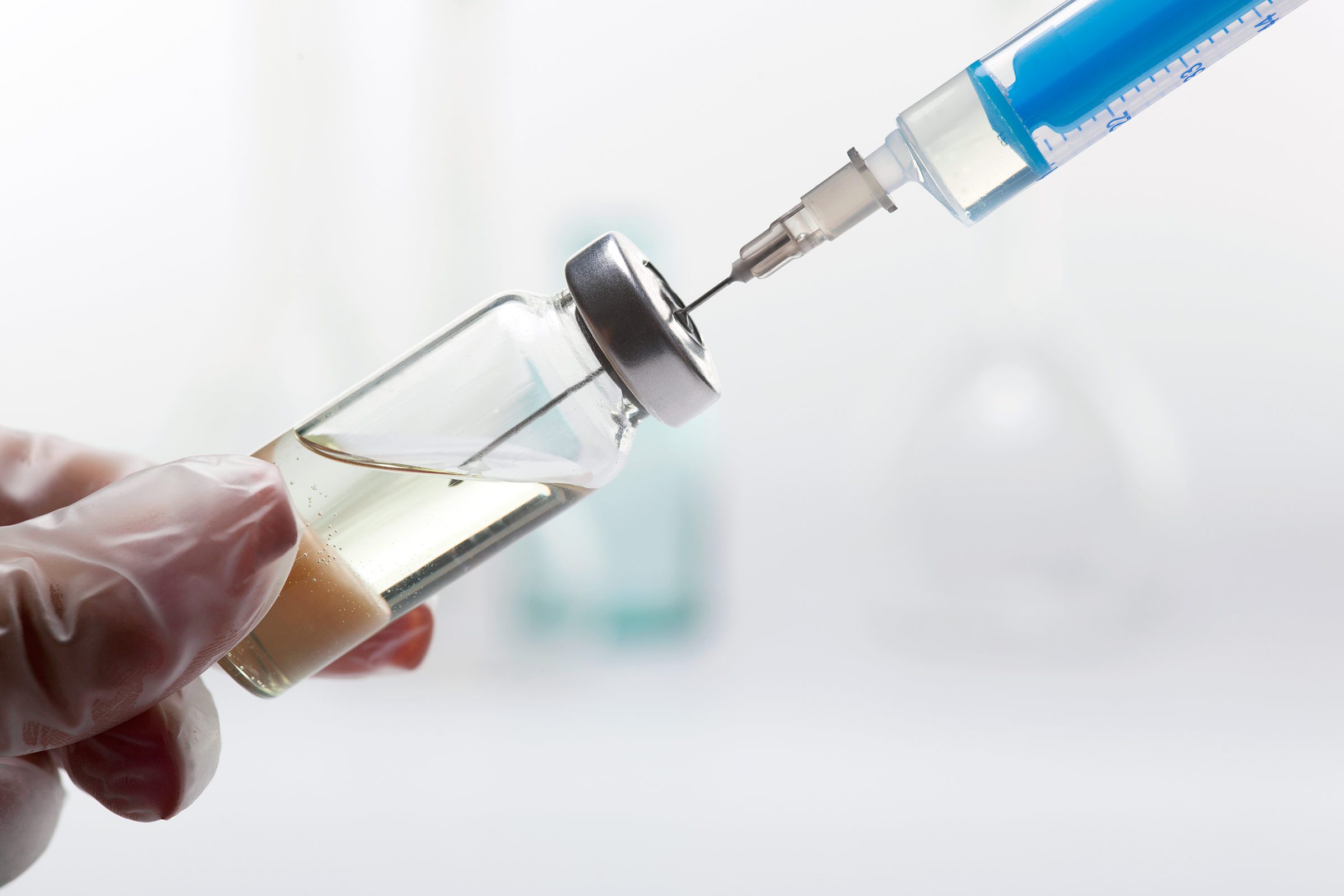 hypodermic syringe in a bottle of clear liquid