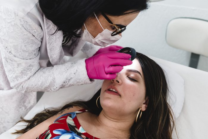 dermatologist examining patient's skin
