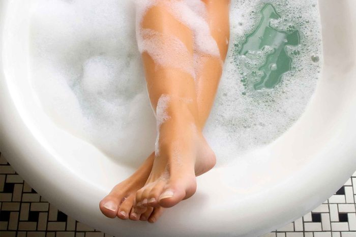 Woman's feet and legs in a bathtub.