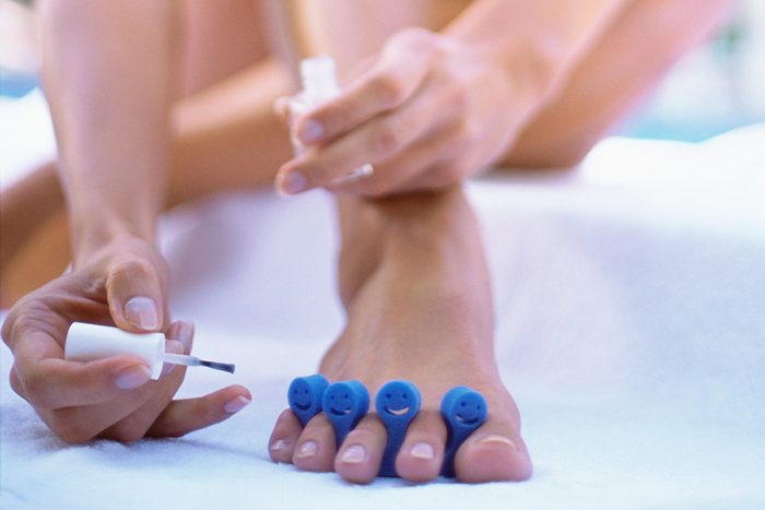 woman giving herself a pedicure