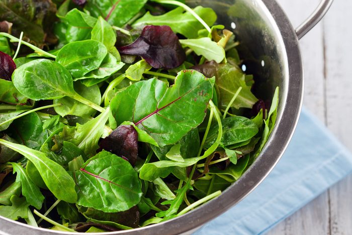 Mixed greens in a colander.
