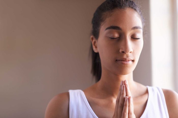woman holding a meditative pose with hands pressed together