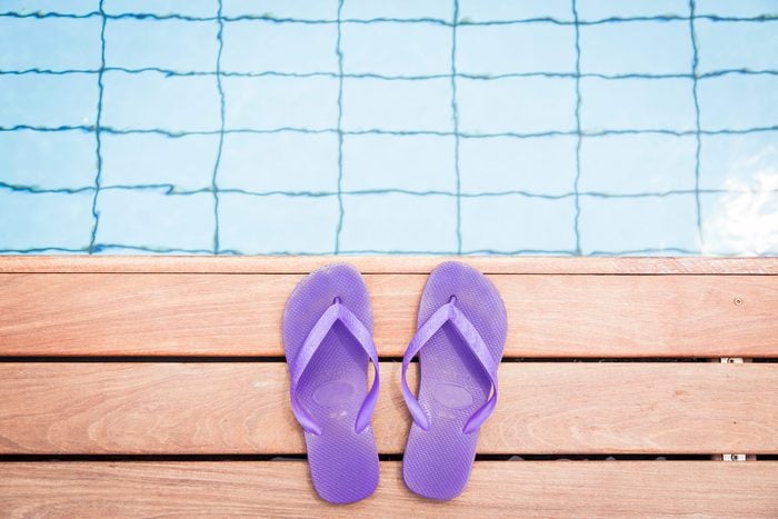 purple flip flops at the edge of a pool