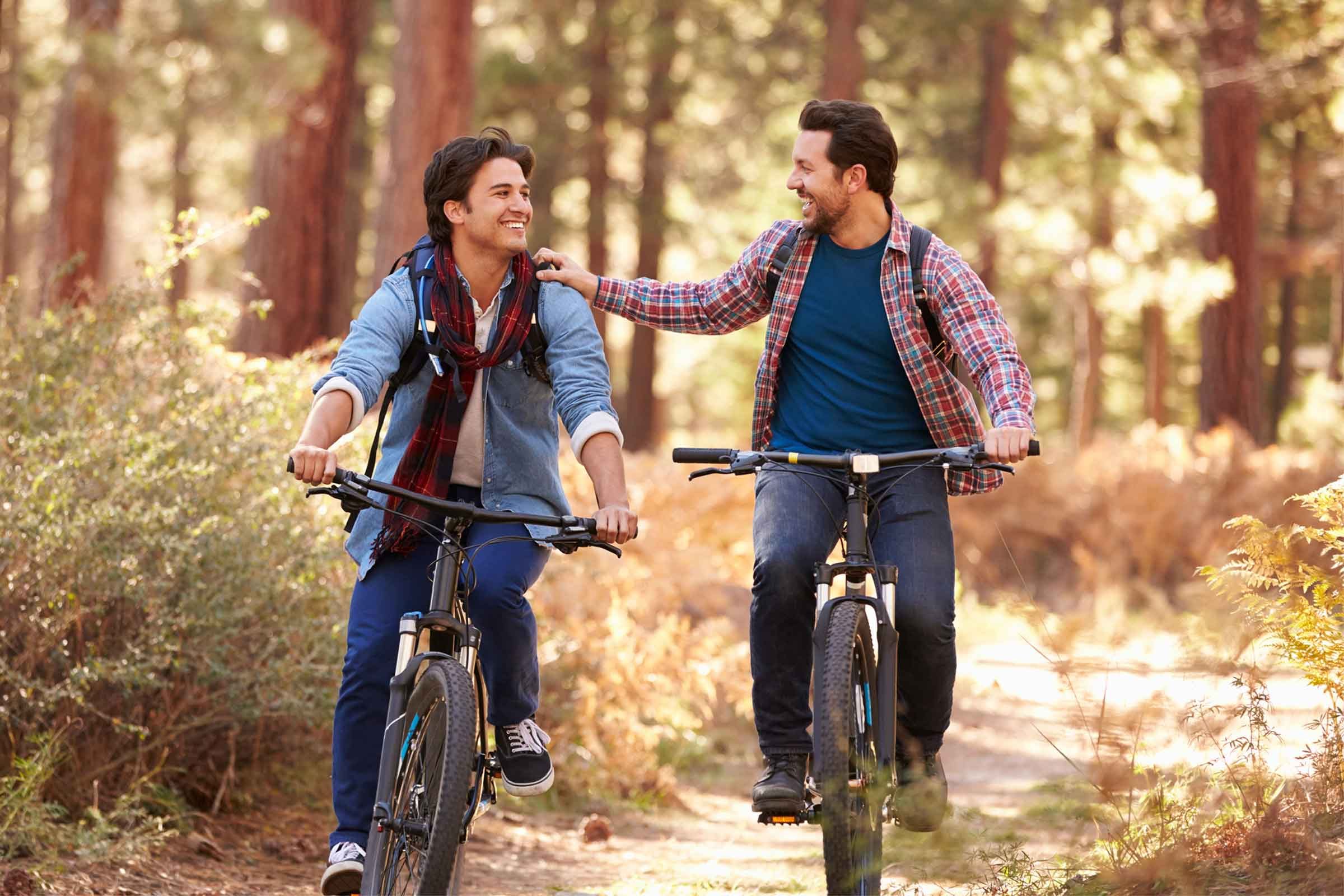 two men riding bike in woods