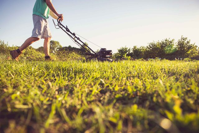 man mowing grass with lawnmower