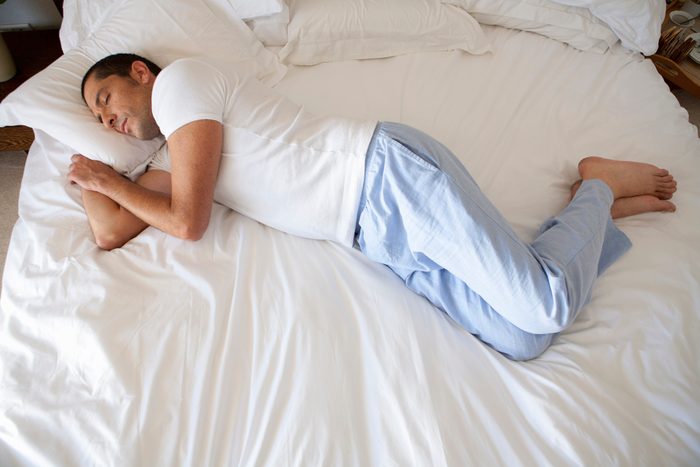 man sleeping on bed with long pajama pants on