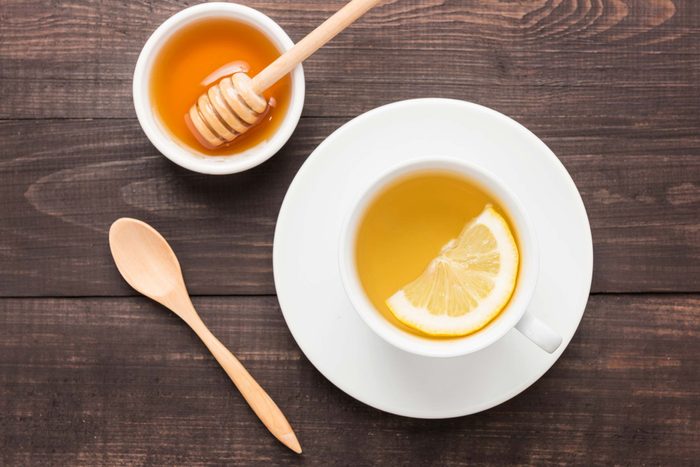 cup of tea with lemon and bowl of honey