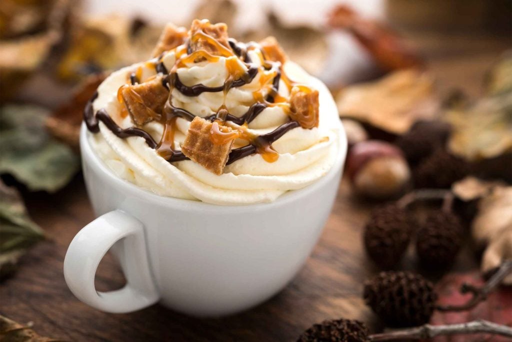 coffee topped with whipped cream, chocolate drizzle, and caramel