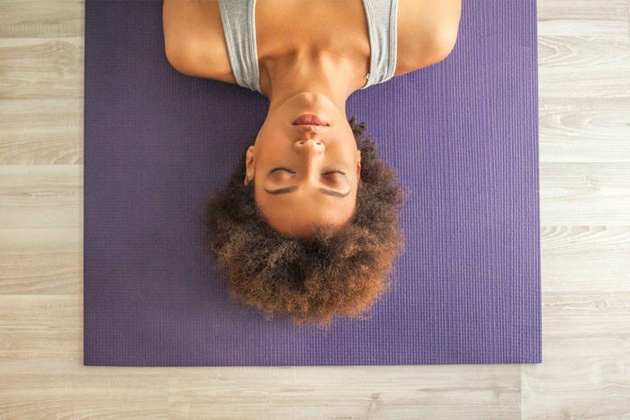 woman on yoga mat with eyes closed