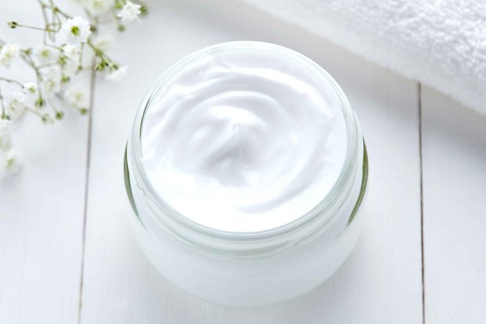 jar of white moisturizer on a white shelf