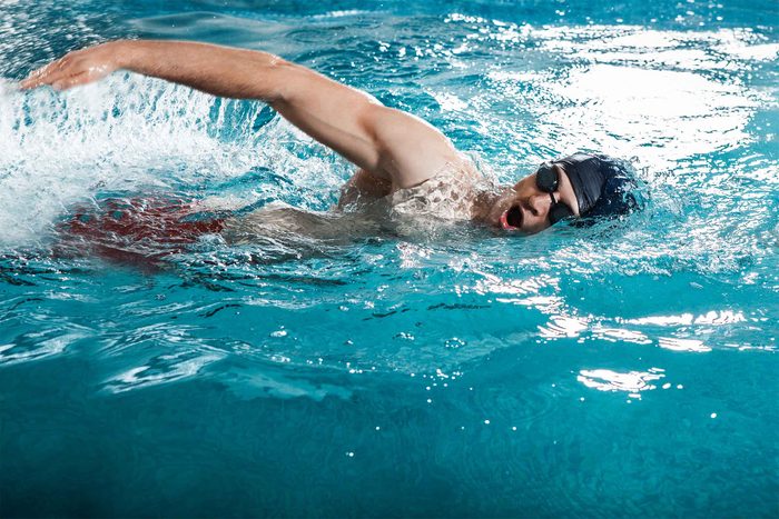 swimmer in goggles doing crawl stroke in pool