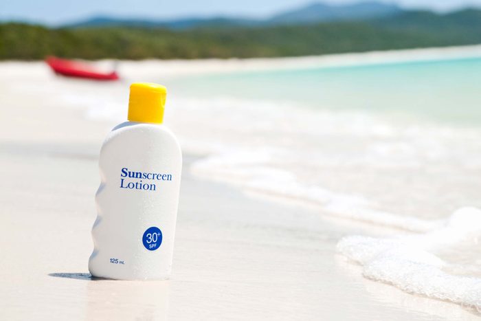 bottle of sunscreen in the sand